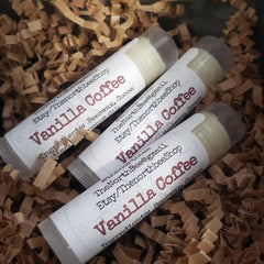 Lip balms with white labels and Vanilla Coffee text, in brown shredded paper, The North Bee brand