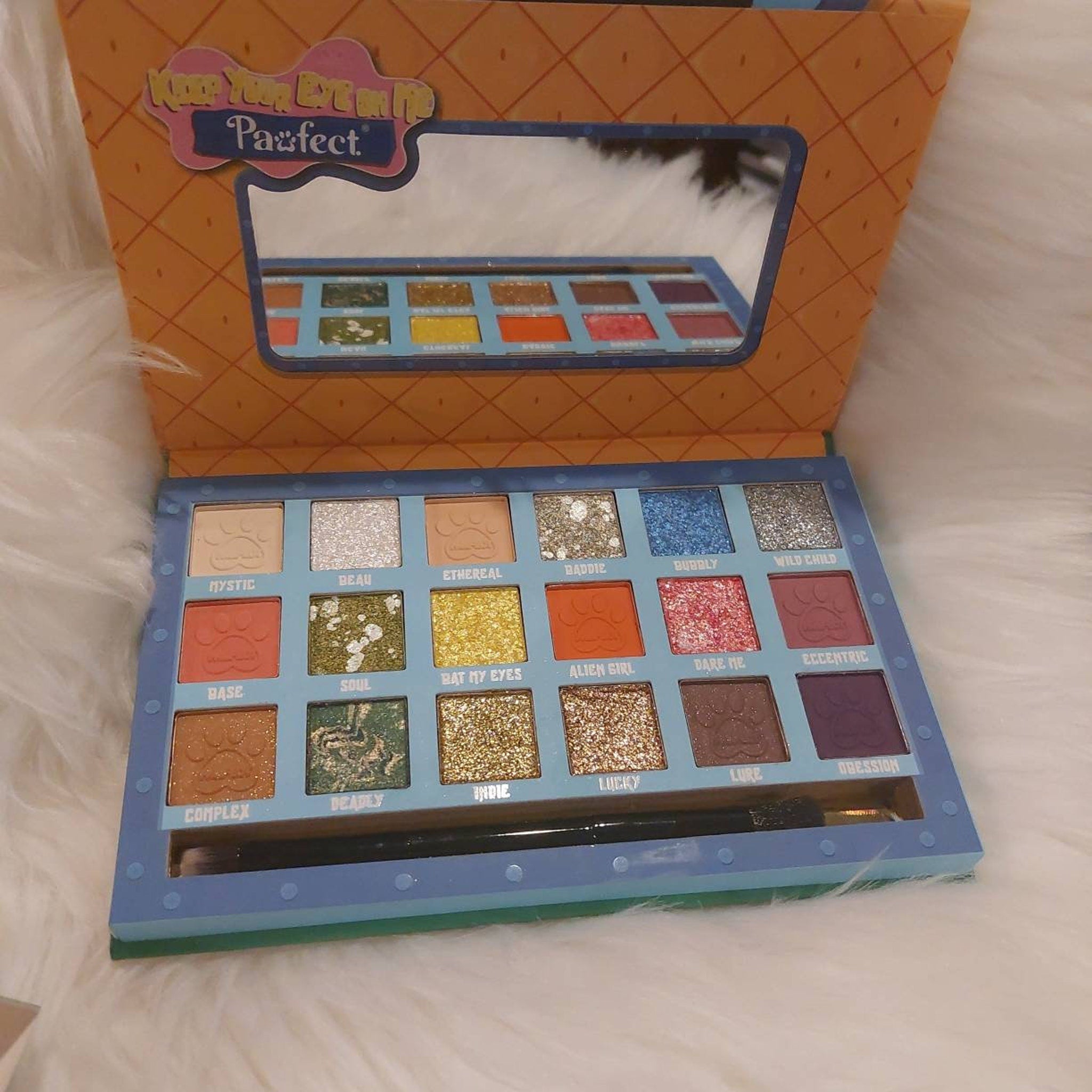 Close-up of Pawfect Eyes on Me palette showing six vibrant matte and shimmer eyeshadow shades in pet-inspired hues