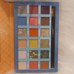 Close-up of fingertips applying shimmery taupe eyeshadow from palette to eyelid crease