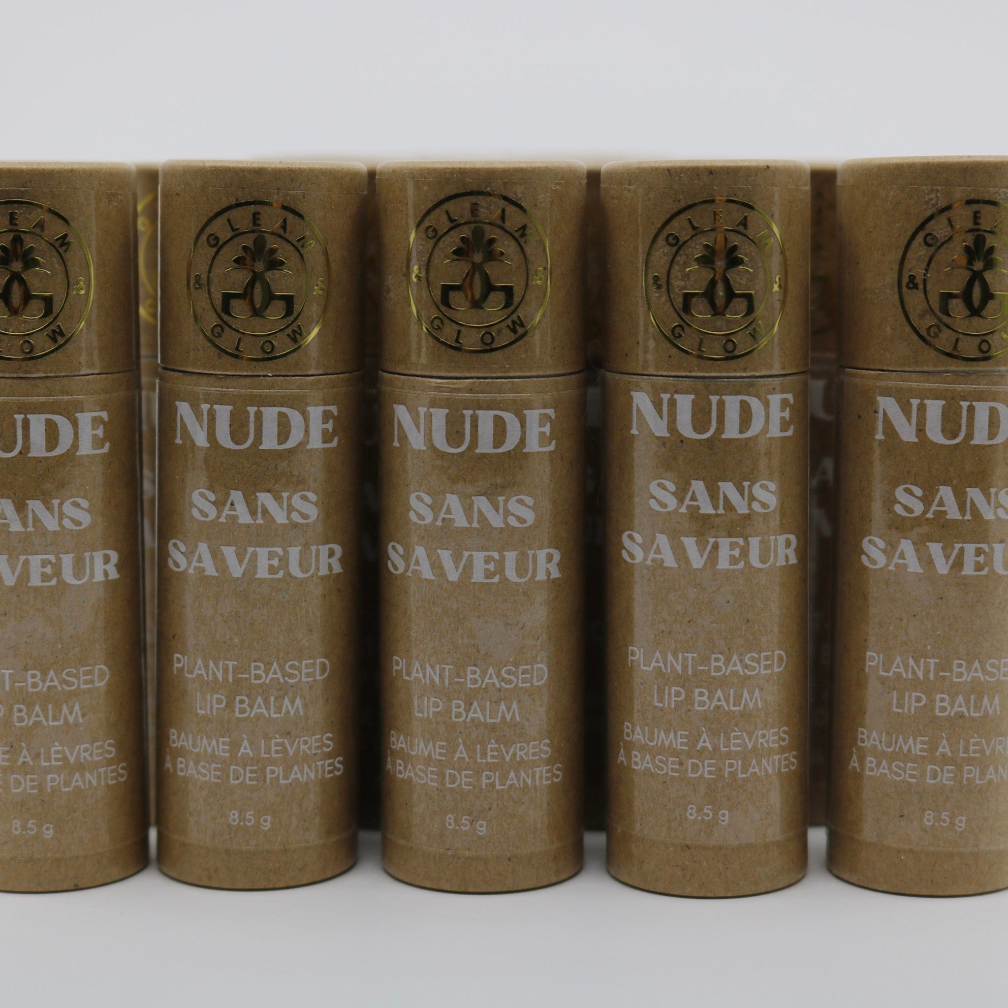 Lip balm tubes in brown cardboard with white and gold text, GLEAM & GLOW brand