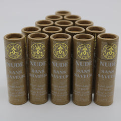 Lip balm tubes in brown cardboard with gold logo and "NUDE" text, arranged in a pyramid