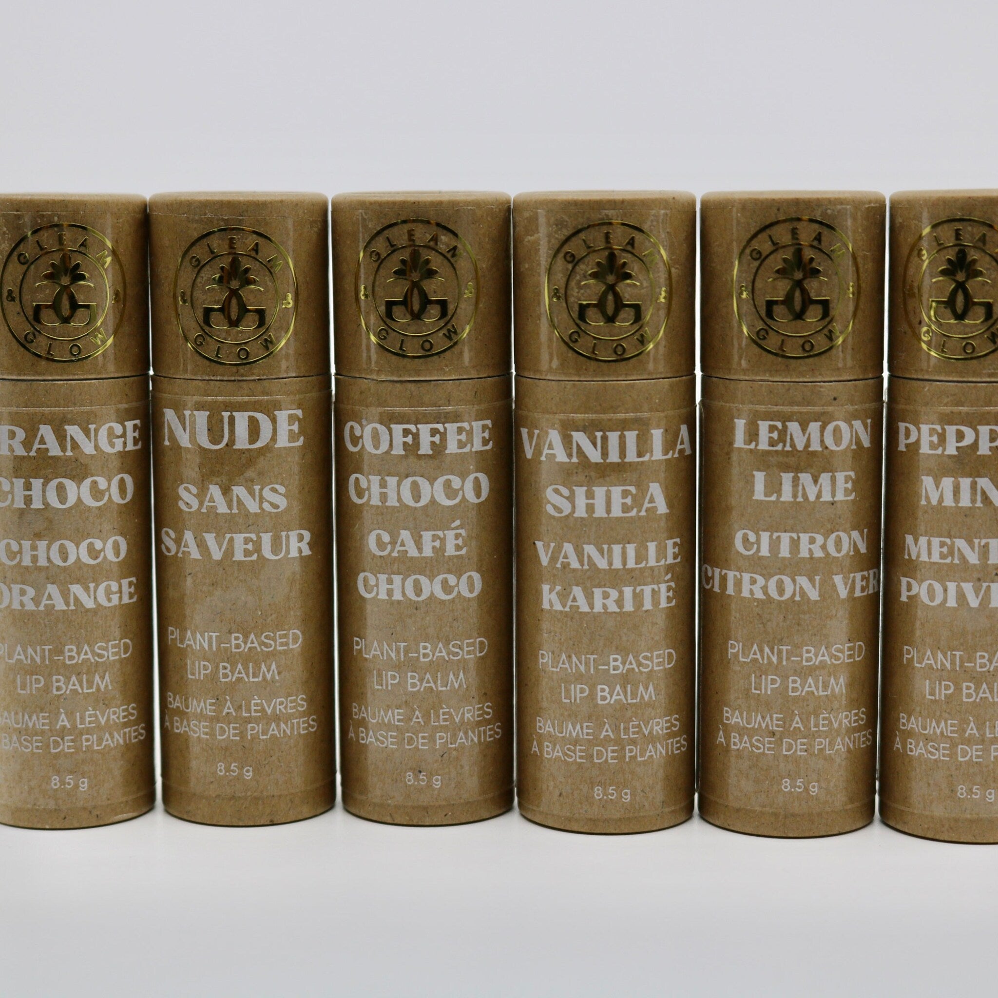 Lip balm tubes in brown cardboard with gold foil logo and text labels