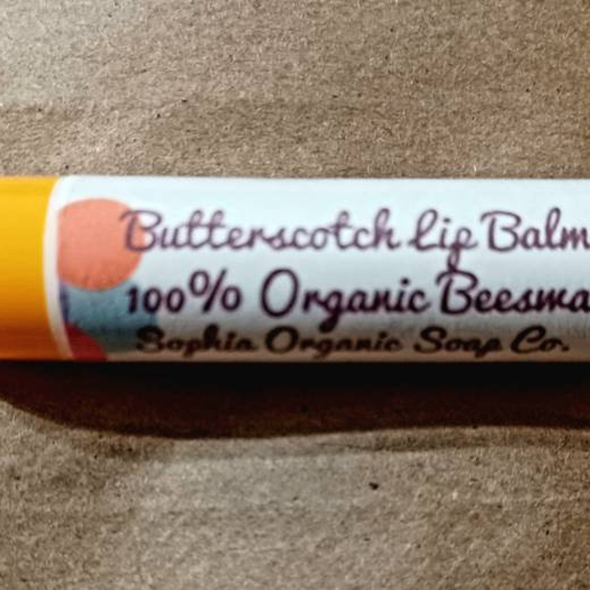 Butterscotch lip balm tube with yellow and white label, Sophia Organic Soap Co. brand name