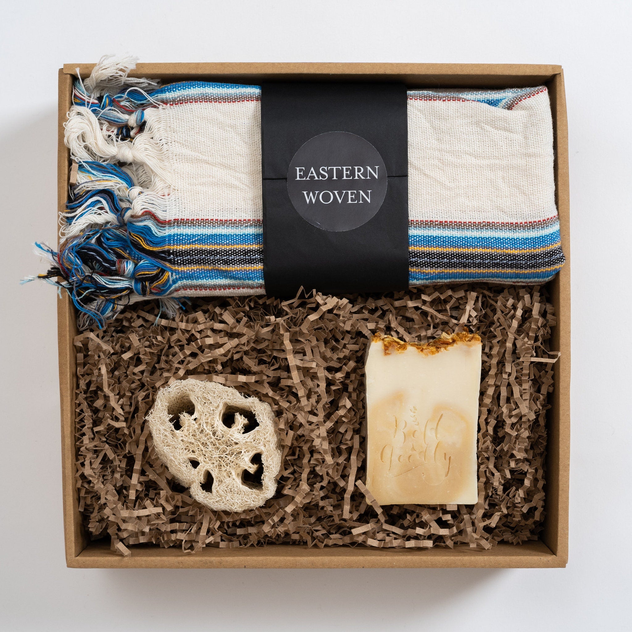 Gift box with woven towel, soap, and loofah in a brown box, Eastern Woven text visible