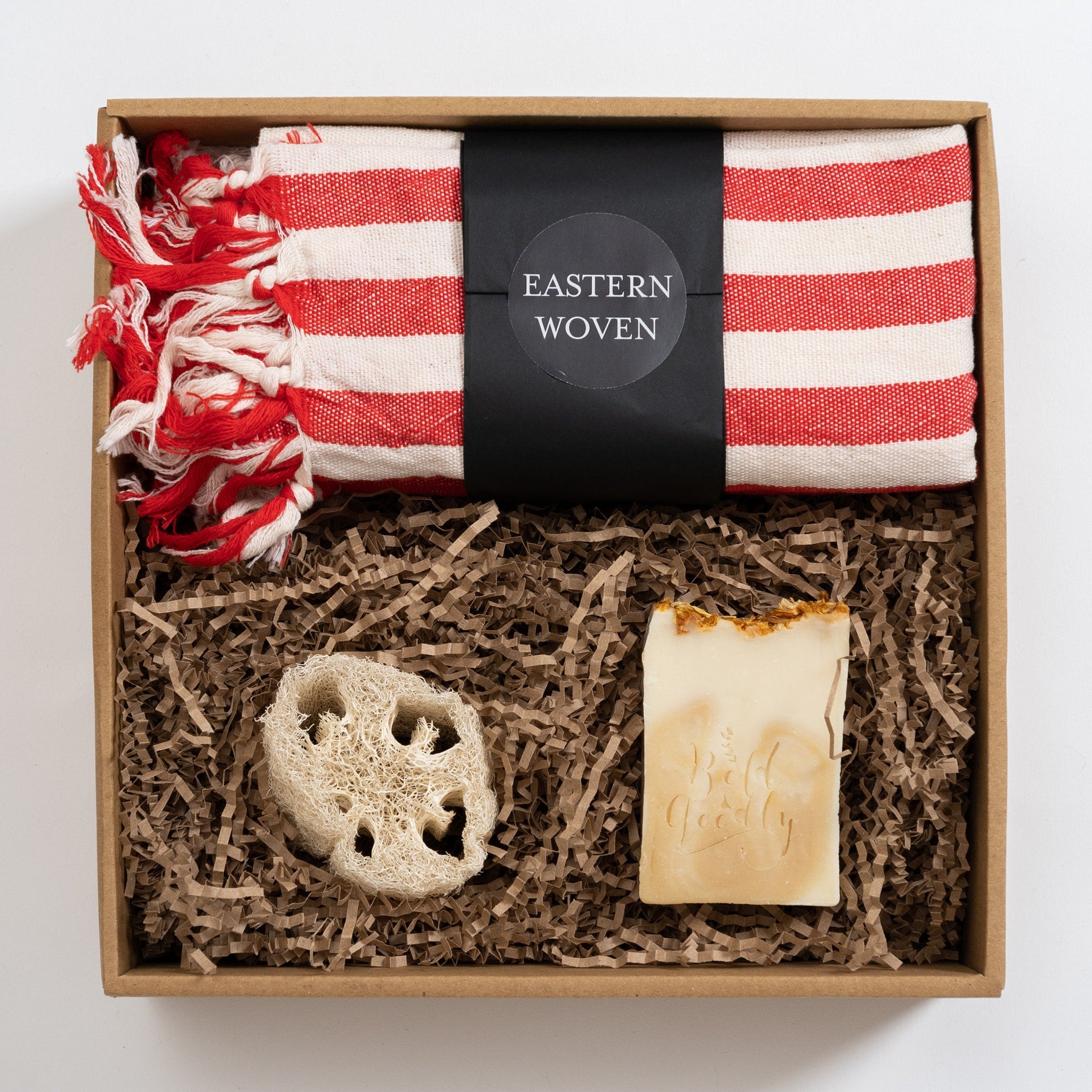 Gift box with red and white striped towel, natural soap, and loofah sponge in a brown box