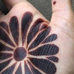 Henna tattoo design with dark brown floral pattern on hand, for body art