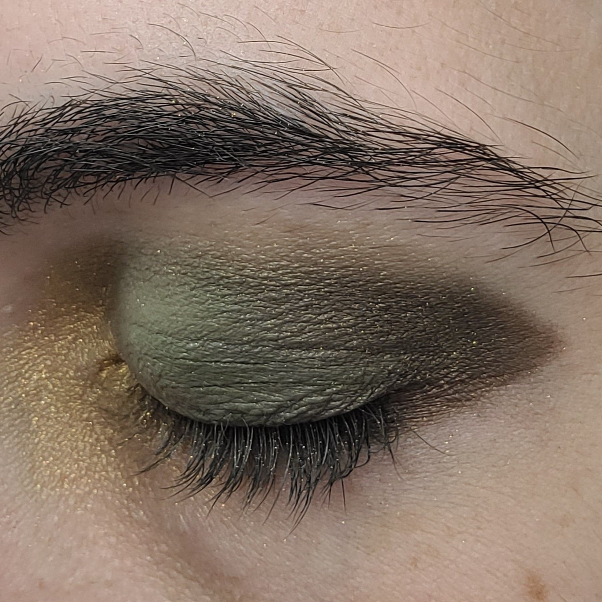 Close-up of matte camouflage eye shadow palette with earthy green and brown tones in compact case