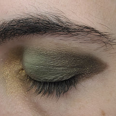 Close-up of matte camouflage eye shadow palette with earthy green and brown tones in compact case