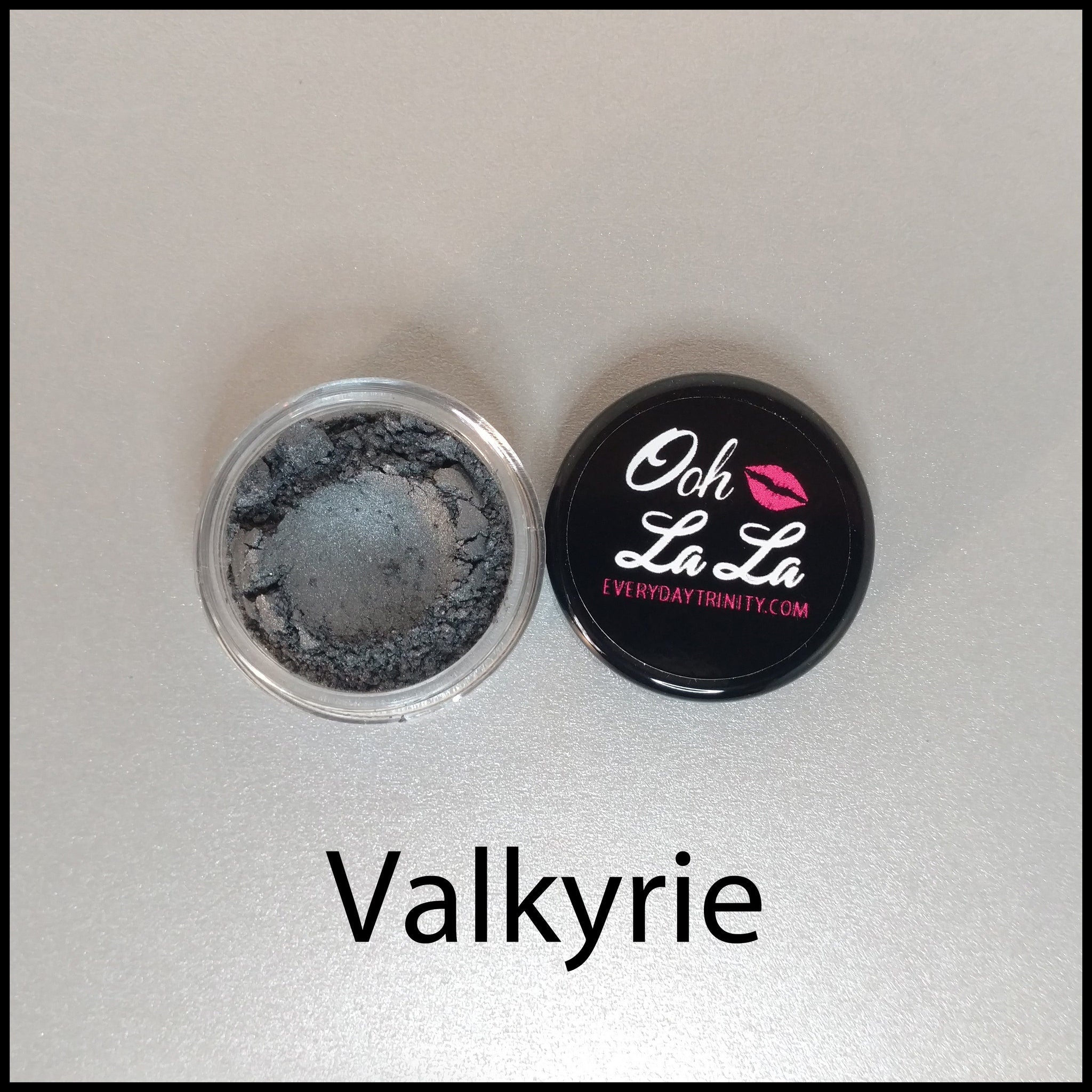 Close-up of black mineral eye shadow in 10g jar showing fine shimmer texture and vegan label details