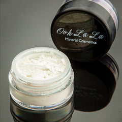 Close-up of vibrant green mineral eye shadow with shimmering flecks in eco-friendly compact