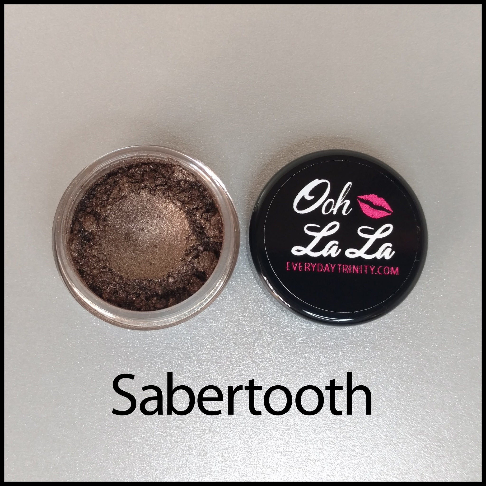 Close-up of open jar showing rich brown and neutral vegan mineral eye shadow powders with soft shimmer finish