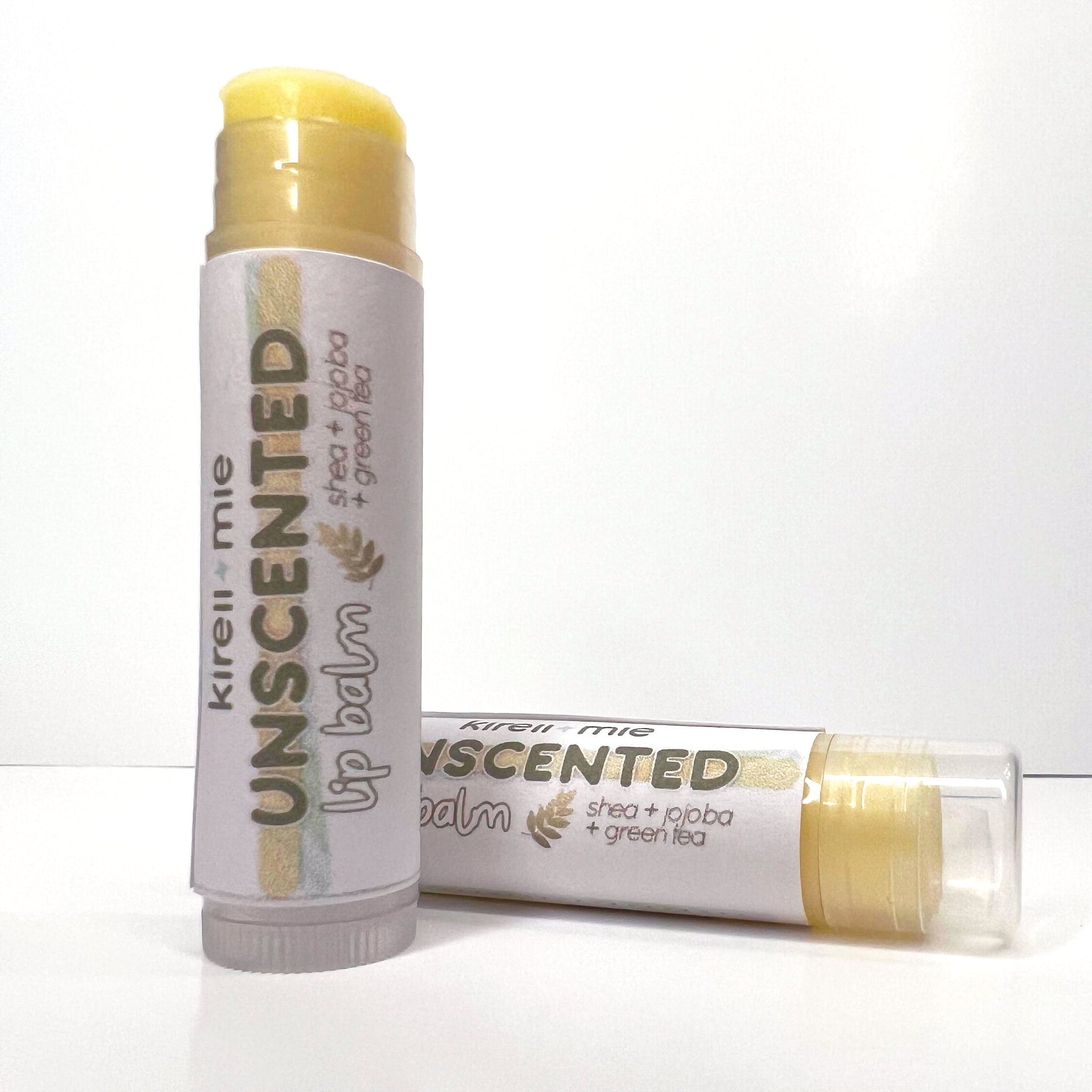 Lip balm tubes with yellow balm, white label, and brand text, Kirell + mie unscented balm