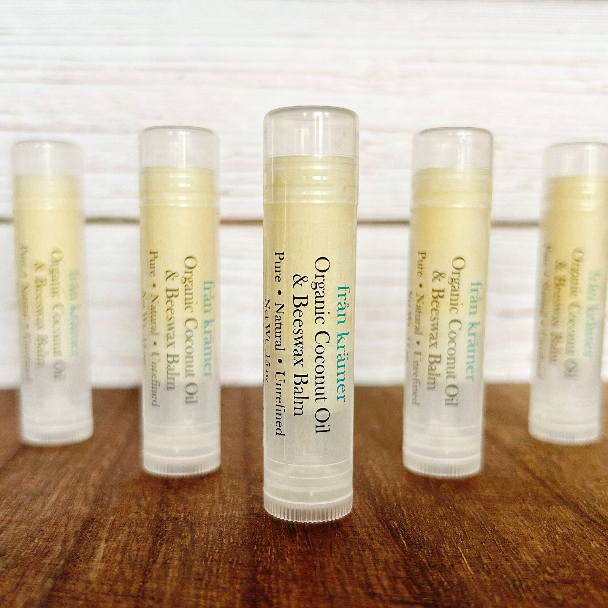 Lip balm tubes with clear plastic caps, yellow balm, and "från krämer" text on white labels