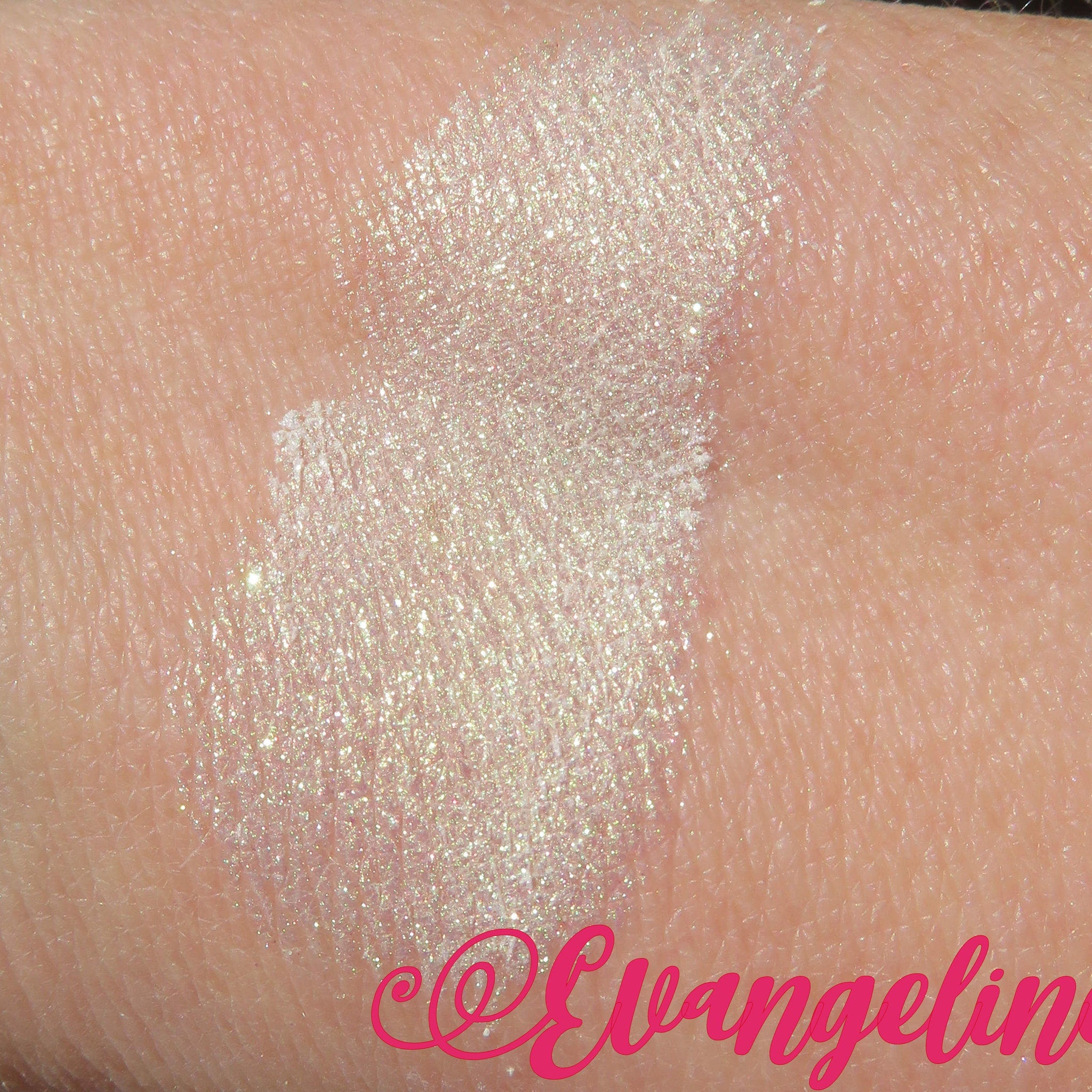 Close-up of loose white shimmer eyeshadow with green gold sheen, vegan mineral pigment in open jar