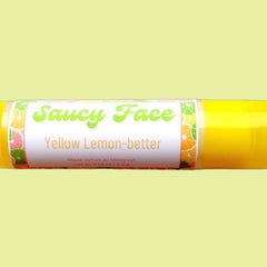 Lip balm tube with yellow and white label, "Saucy Face" text, and fruit pattern around the label.