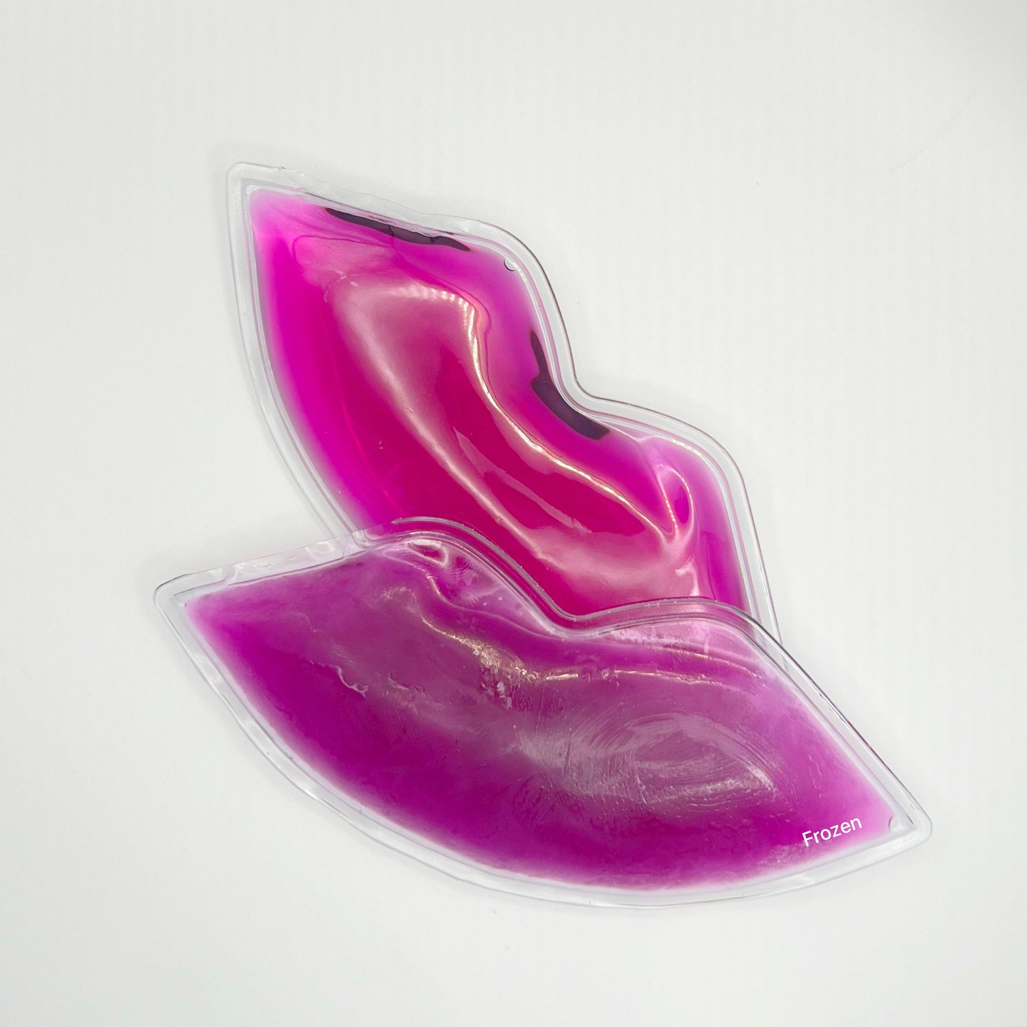 Lip-shaped gel pack in pink liquid, clear plastic, with "Frozen" text visible on the corner.