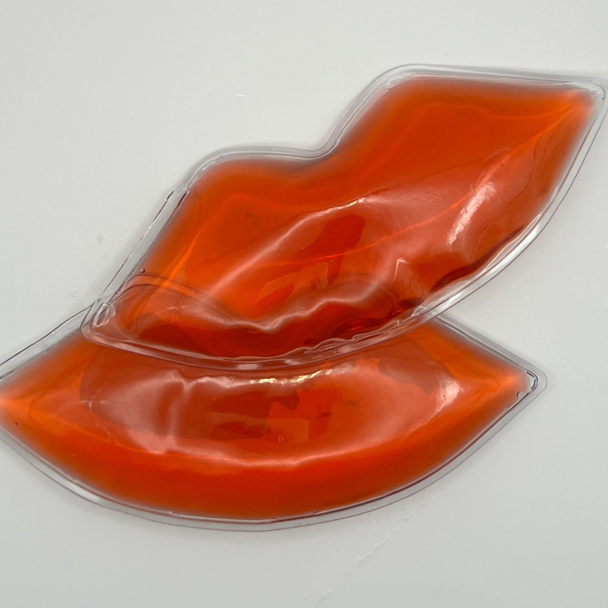 Lip-shaped gel pack, orange gel, clear plastic border, lip shape design