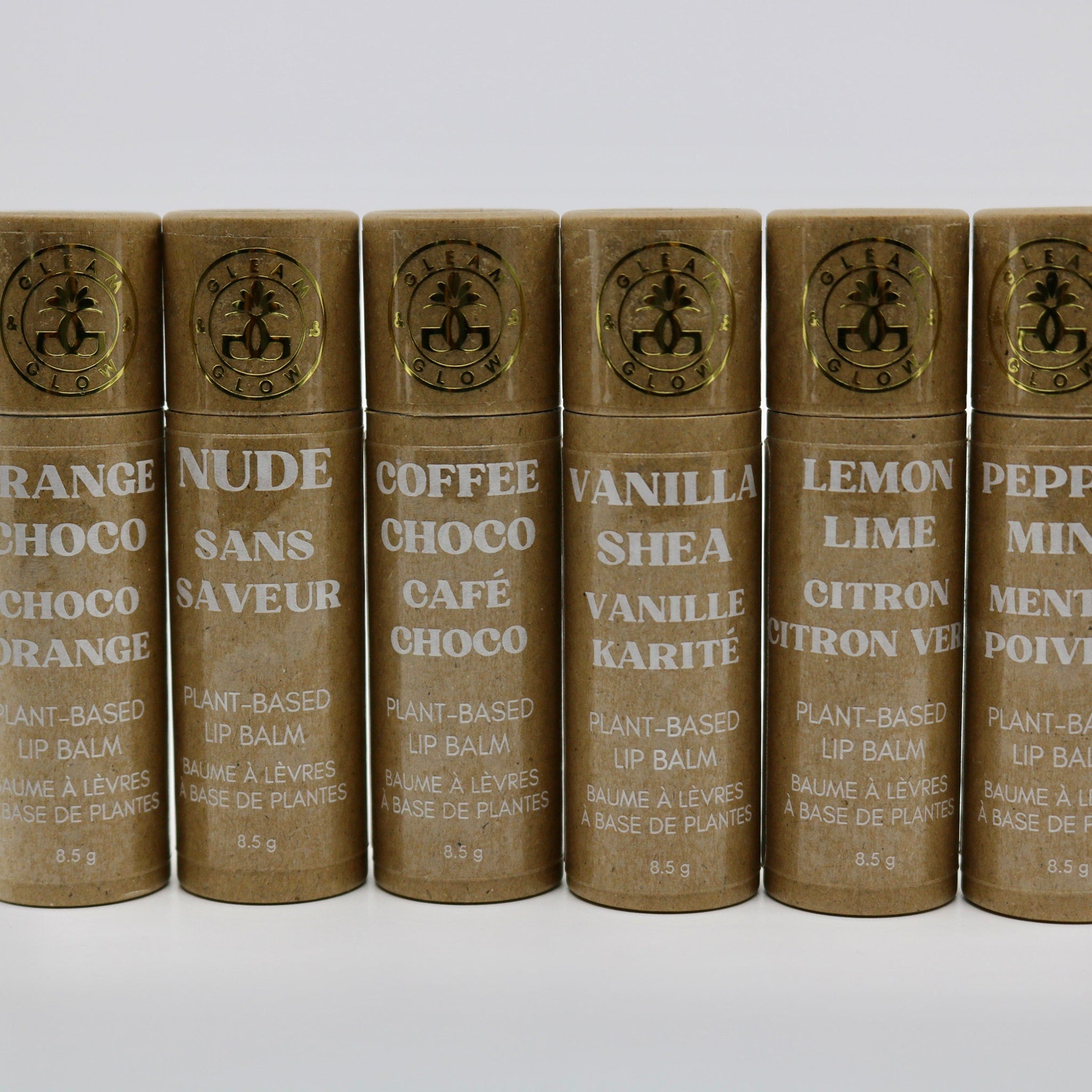 Plant-based lip balms in brown paper tubes with gold foil logo, various flavors displayed