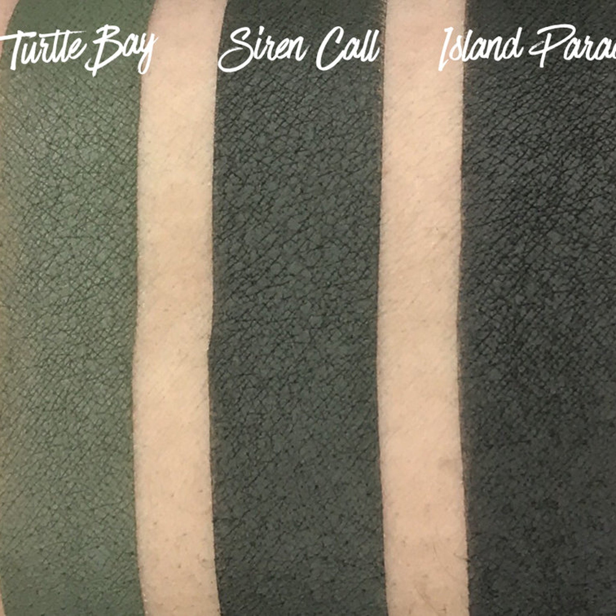 Side view of matte pressed eyeshadow pan in tropical blue shade with smooth texture and clean edges