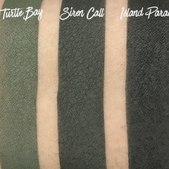 Side view of matte pressed eyeshadow pan in tropical blue shade with smooth texture and clean edges