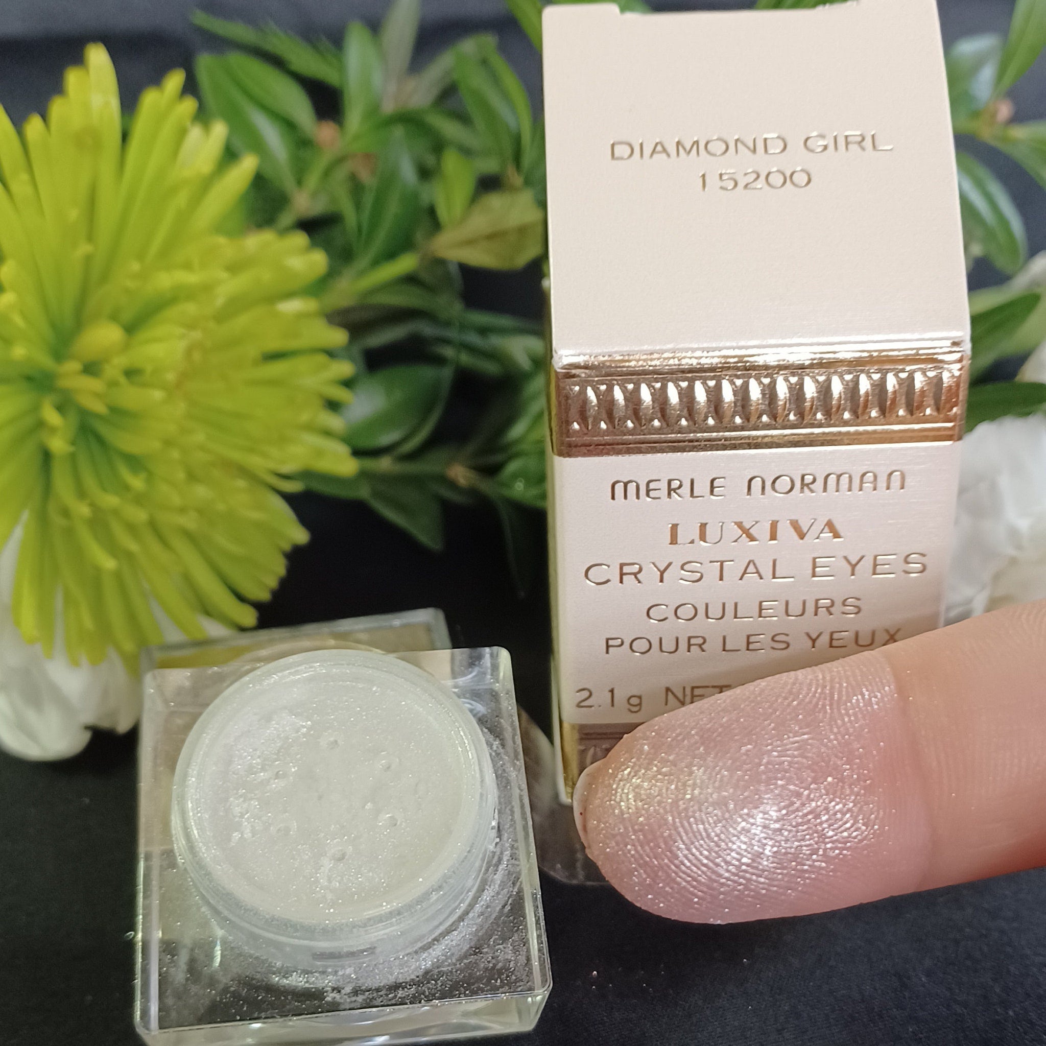Hand applying loose silver glitter eyeshadow with fingertip for sparkling eye makeup look