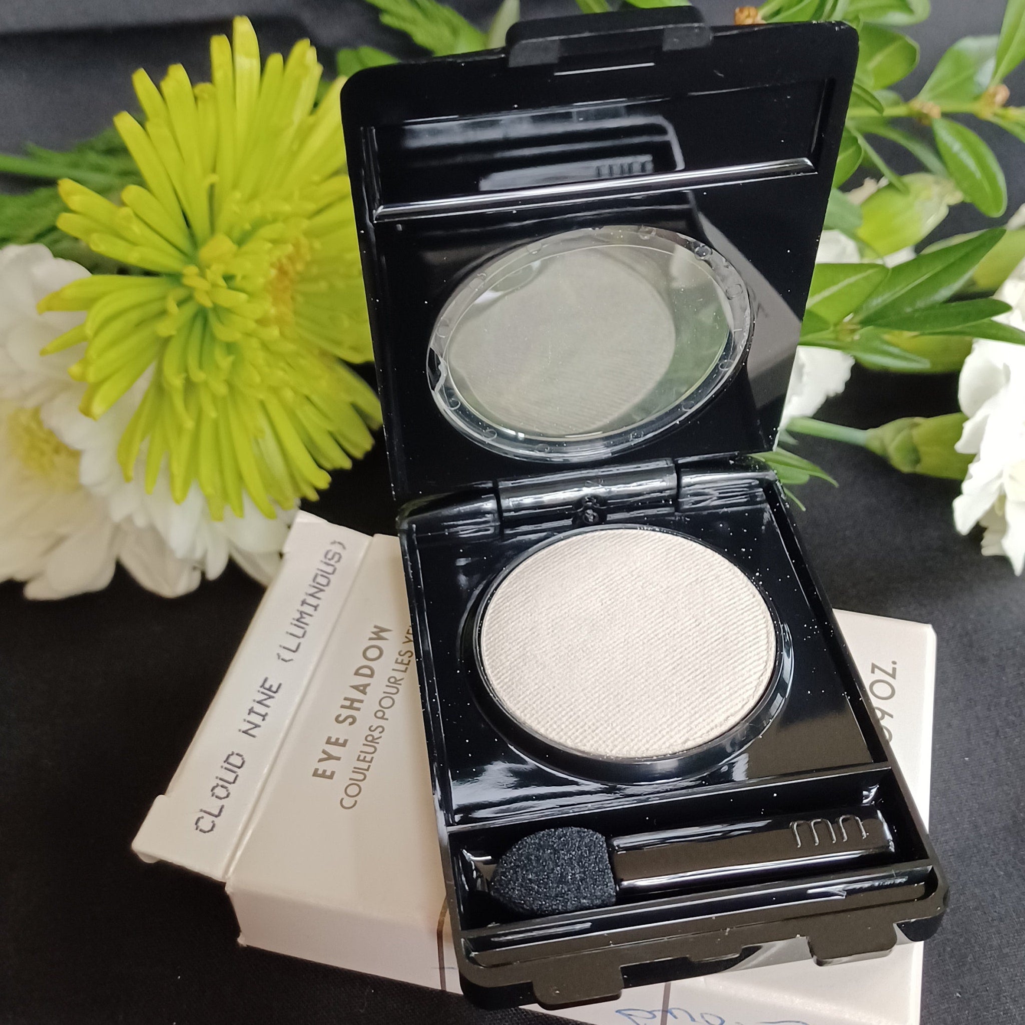 Side view of Merle Norman loose glitter eyeshadow jar showing sparkling powder texture and reflective particles