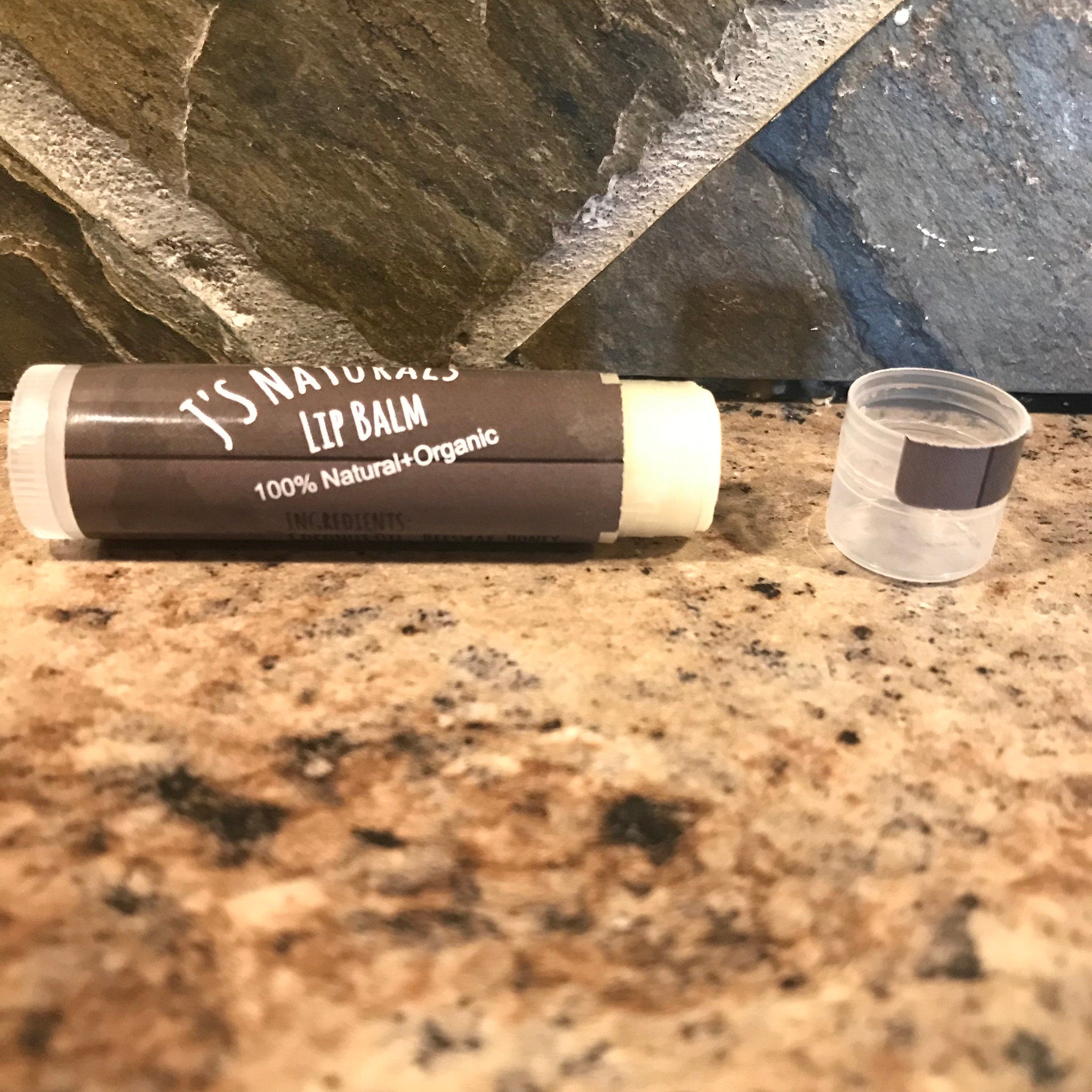 Lip balm tube with brown and white label, clear cap, and text "J's Naturals Lip Balm