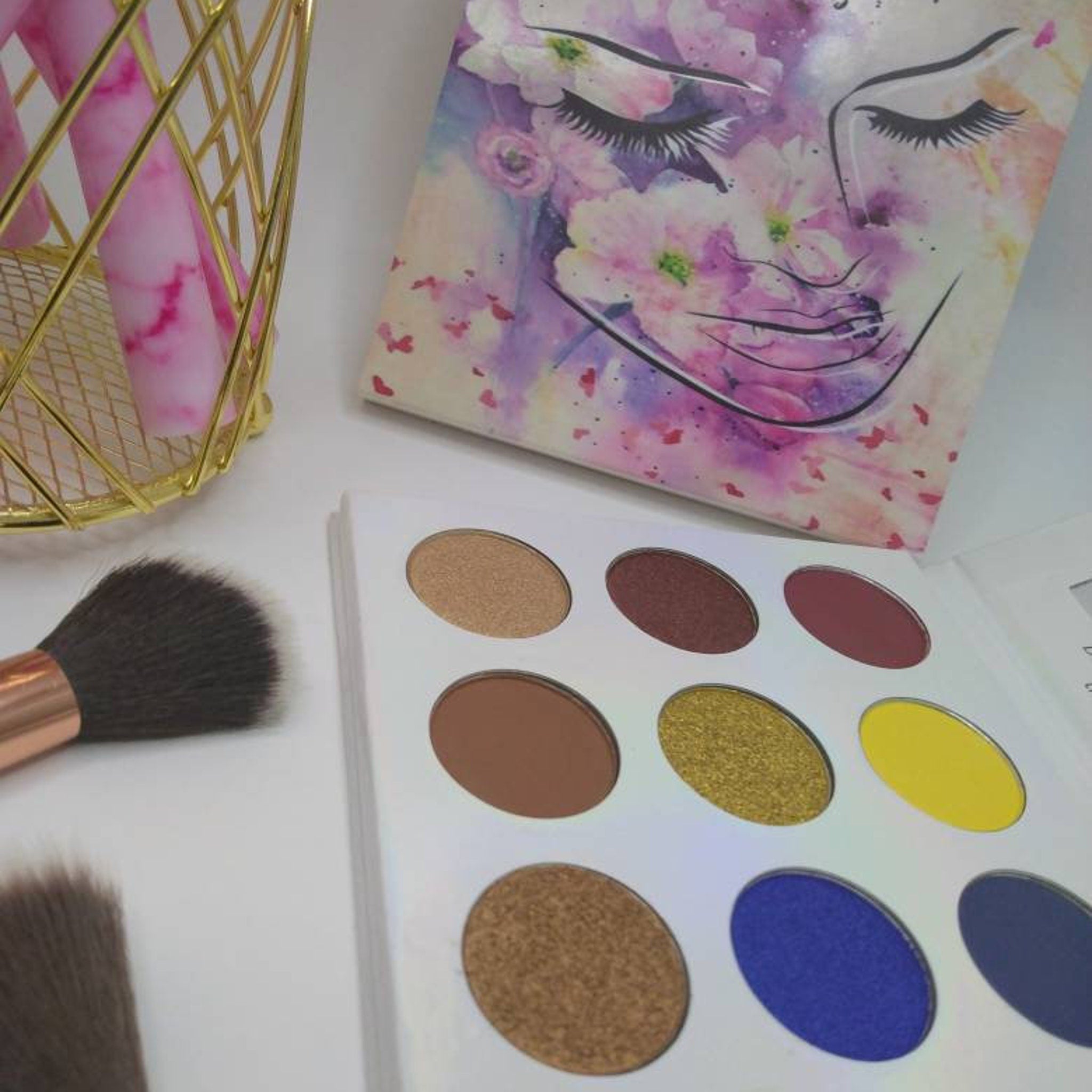 Square eye shadow palette with six matte and shimmer shades in warm neutrals and deep plum tones