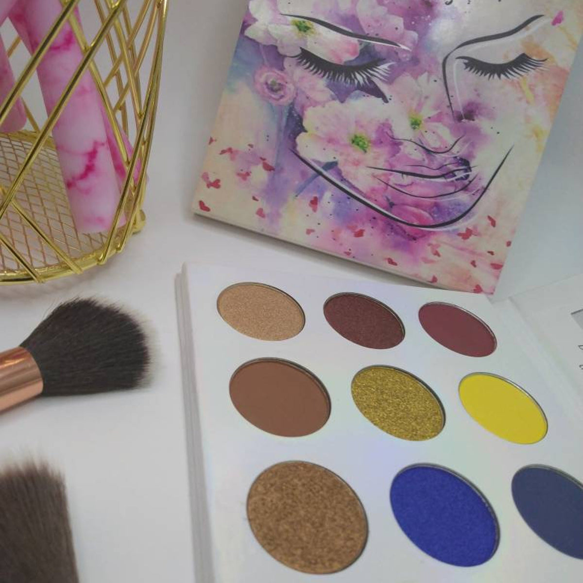 Square eye shadow palette with six matte and shimmer shades in warm neutrals and deep plum tones