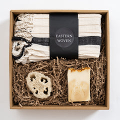 Gift set with Eastern Woven towel, natural loofah, and soap in a cardboard box with shredded paper