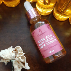 Face serum bottle with pink label, glass bottle, and Chanita's Naturals branding visible on a wooden surface