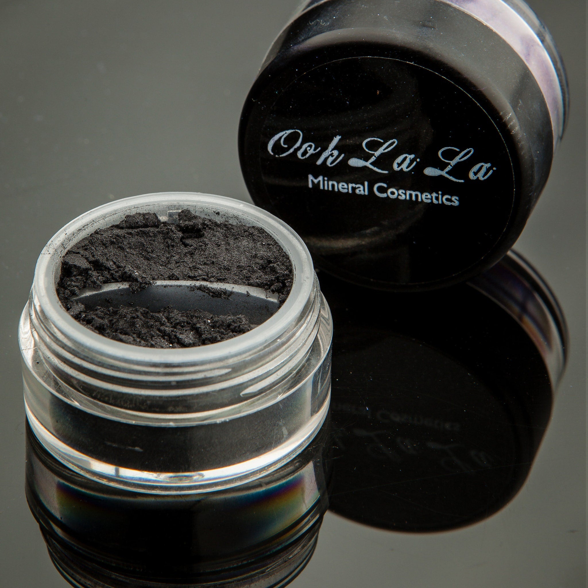 Side view of white, silver, and black mineral eye shadow in a 10g jar with vegan and cruelty-free label visible
