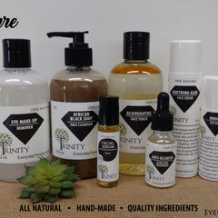 Skincare products with black, white, and clear bottles, various liquids, and Trinity branding on a burlap surface
