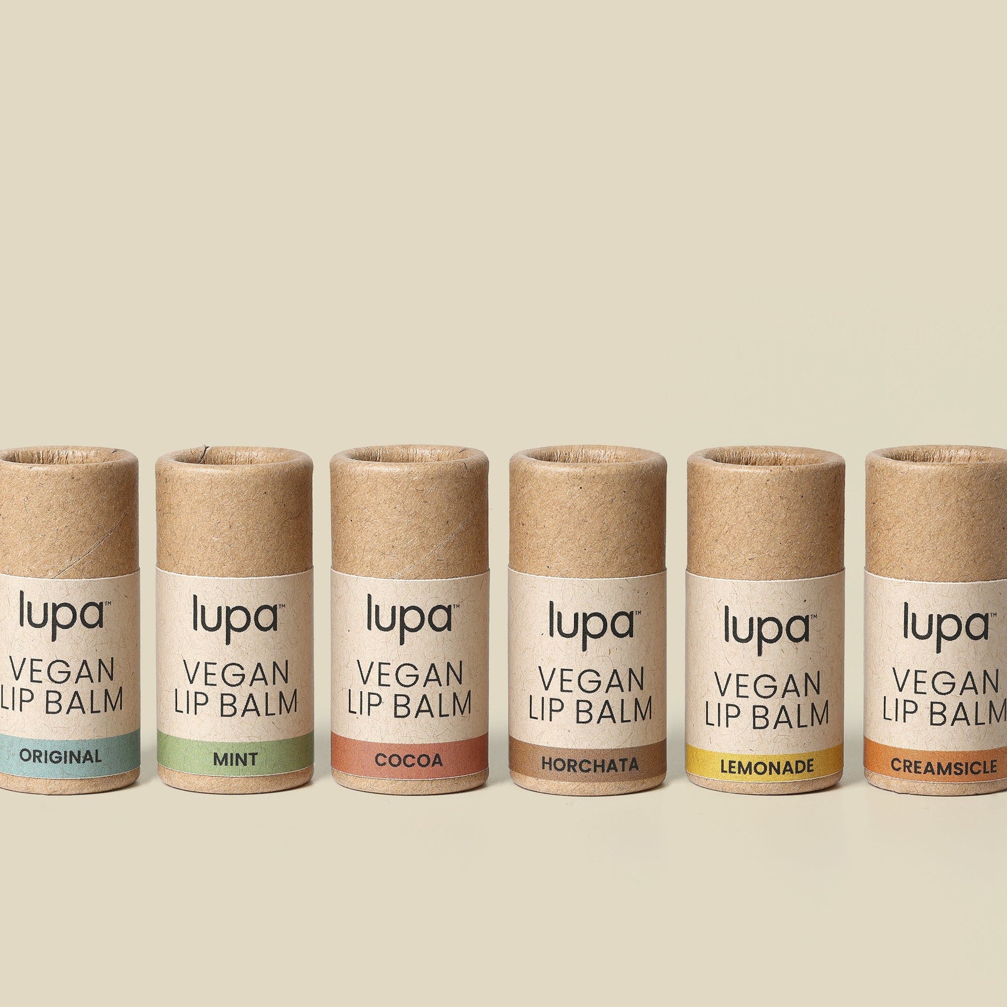 Vegan lip balm tubes in brown cardboard with Lupa brand text and colored labels