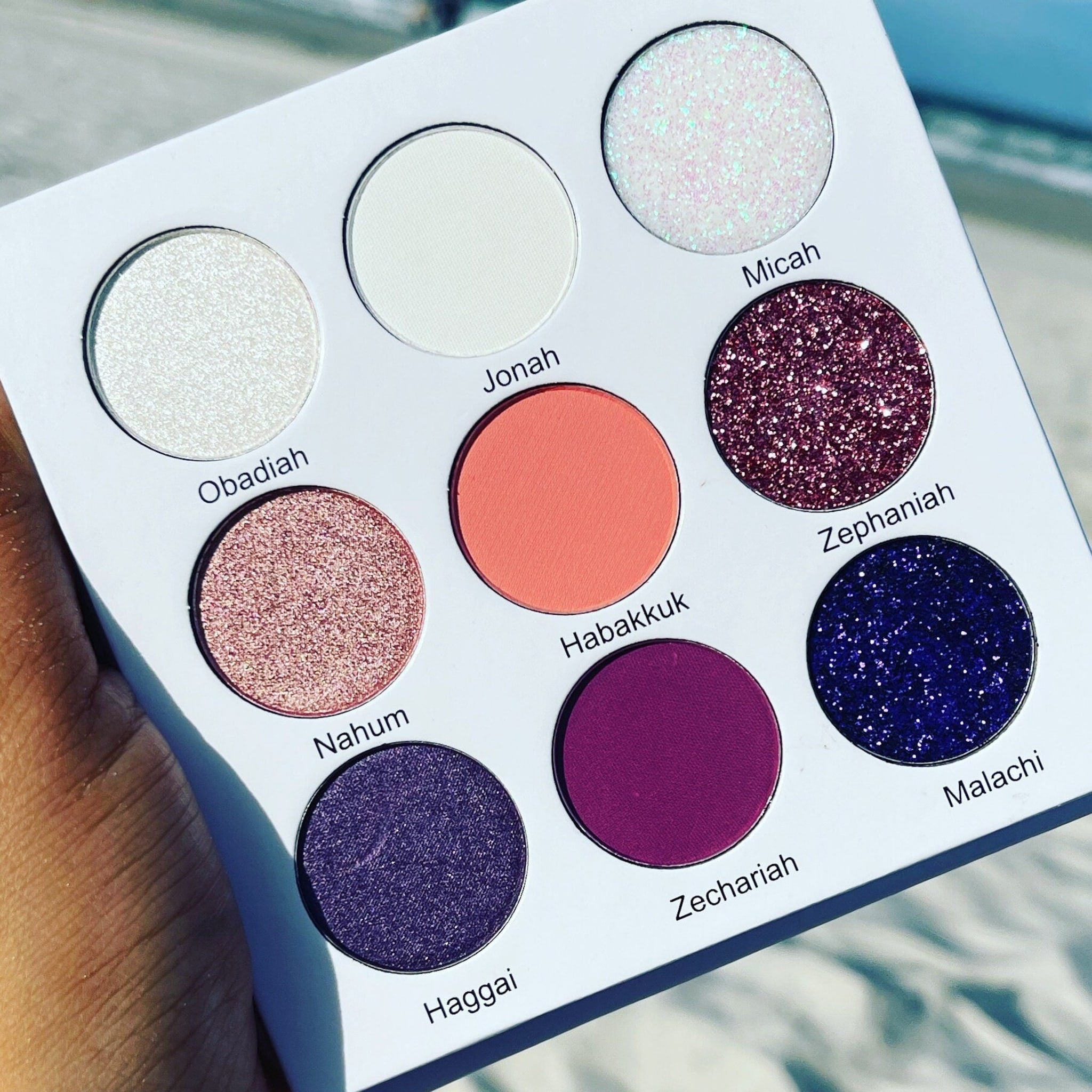 Eyeshadow palette with multiple colors, glitter, and text "My Colorful Bible" on white background