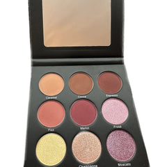Eyeshadow palette with various colors including brown, pink, and gold, in a black compact with a mirror.