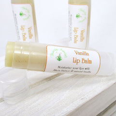 Lip balm tube with white and gold label, light yellow balm, and clear plastic tube