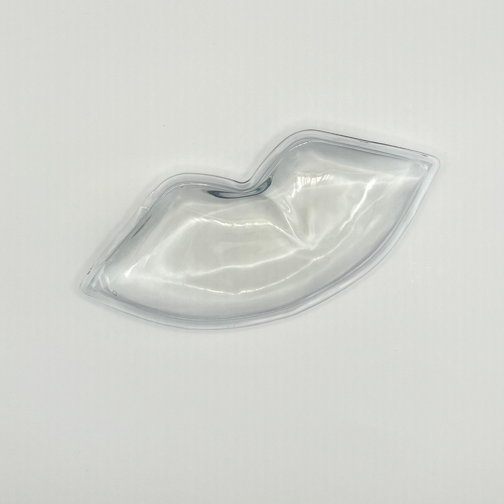 Lip-shaped clear plastic dish with curved edges, on white background