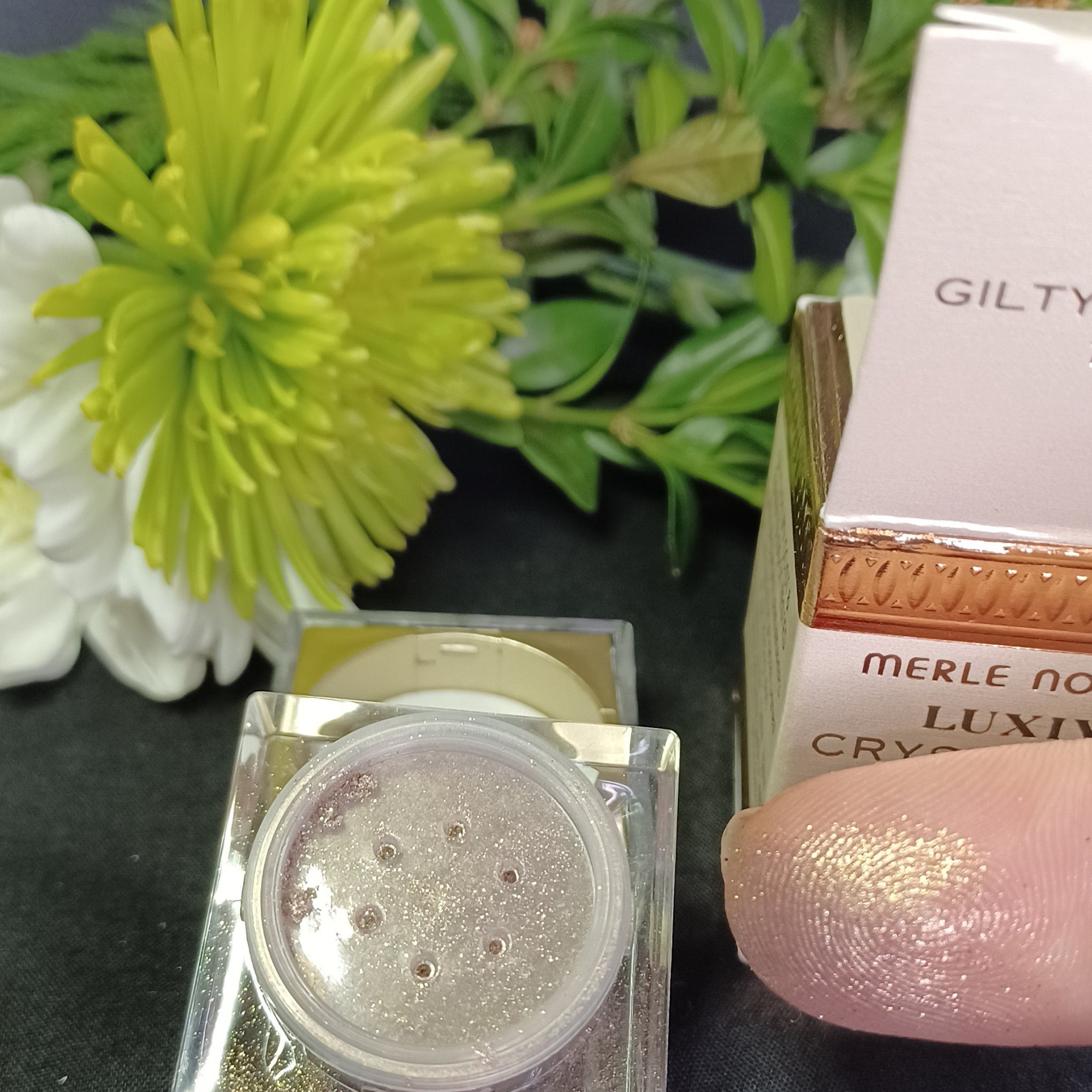 Close-up of loose glitter eyeshadow particles shimmering in golden and silver hues