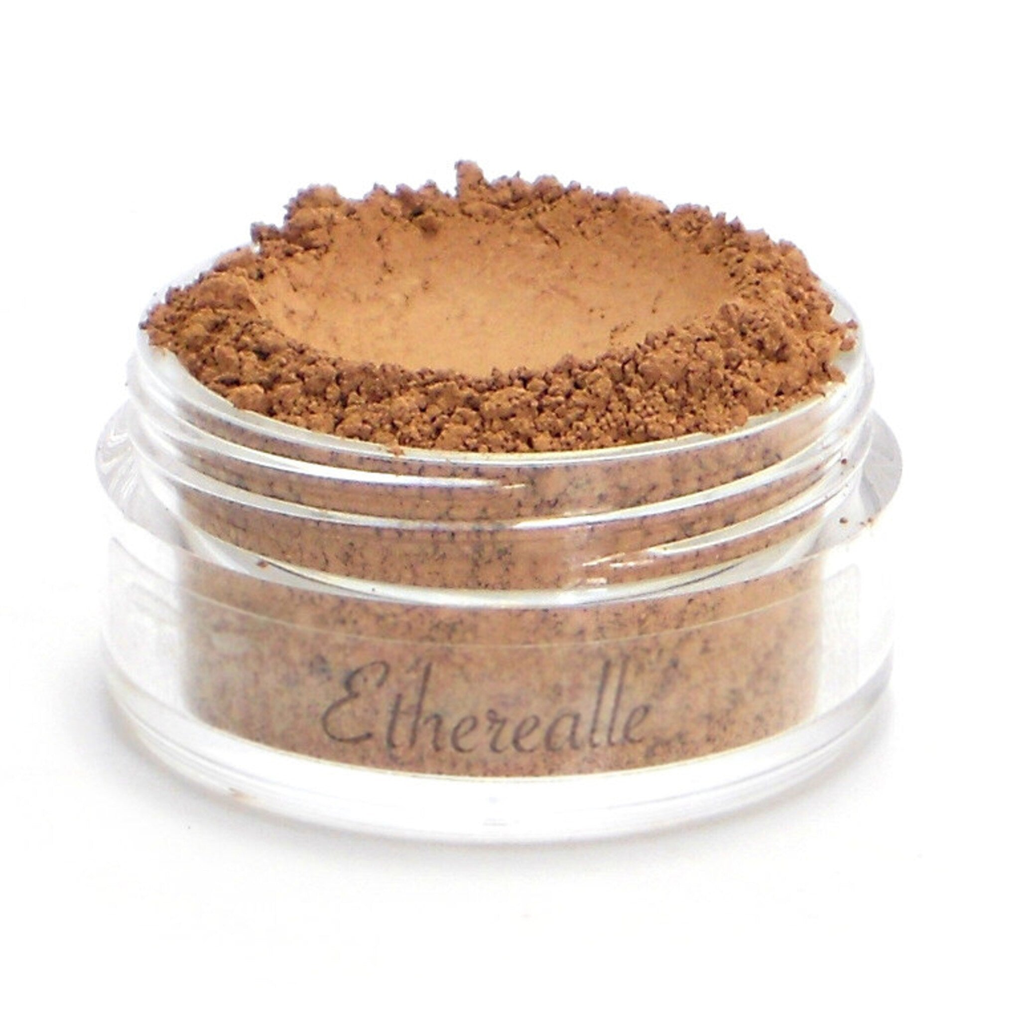 Powder makeup in a clear jar with brown powder and Etherealle text visible
