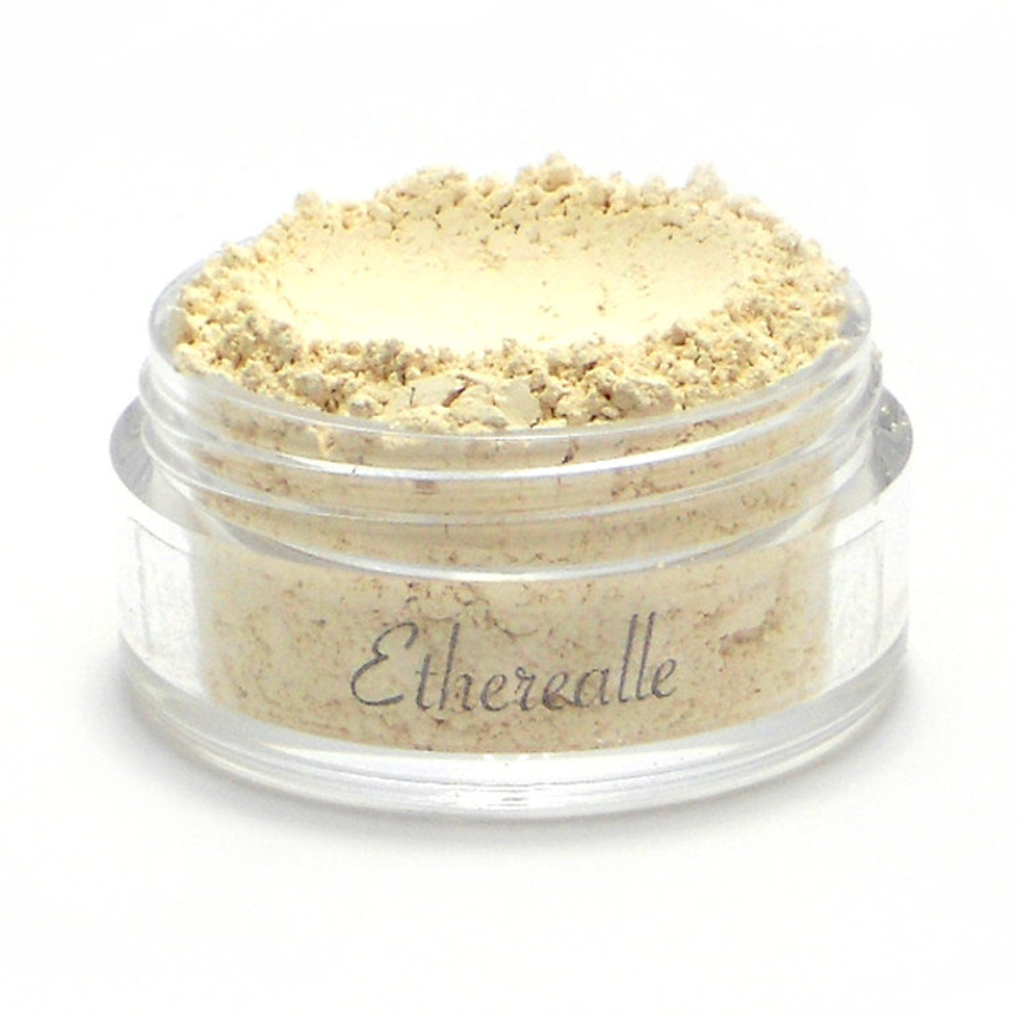 Side view of creamy off-white matte eyeshadow pan with smooth mineral texture in compact packaging