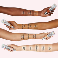 CC+ cream swatches on arms in various shades of beige, tan, and brown, with product tube visible