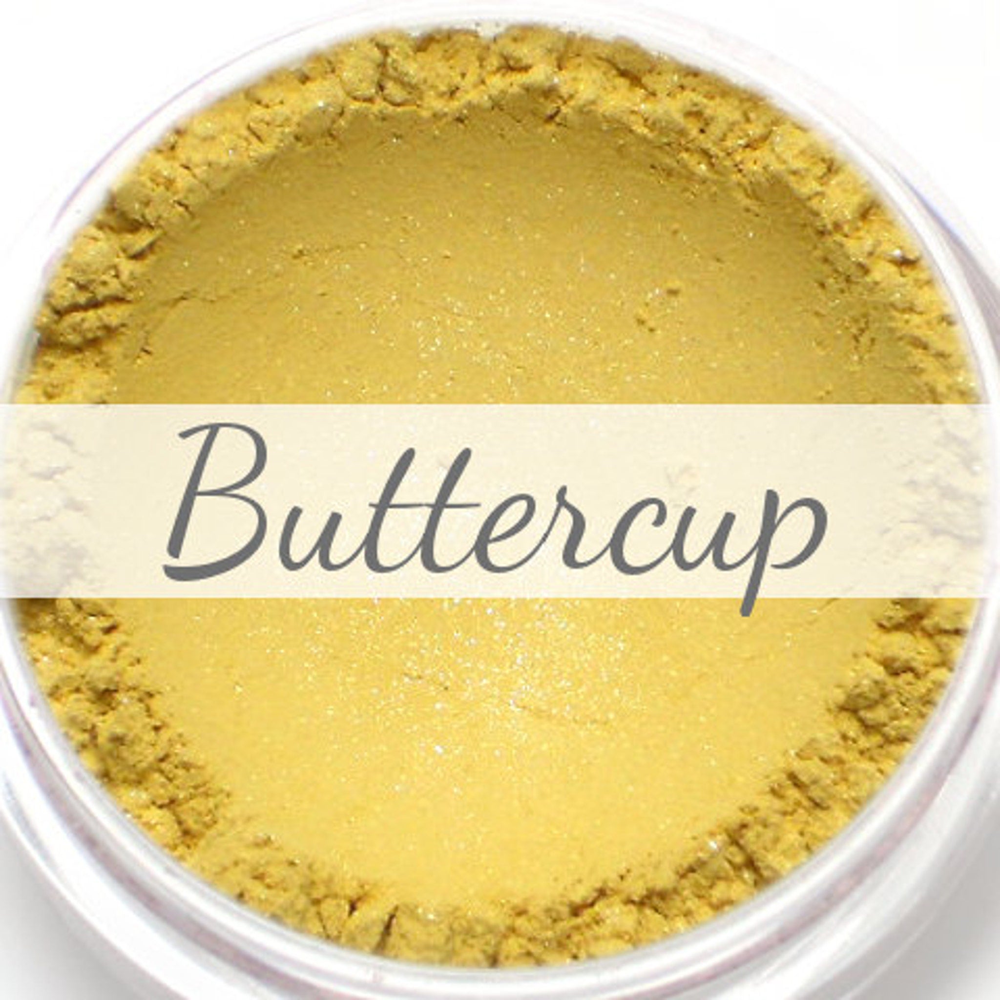 Shimmery pale yellow vegan mineral eyeshadow in compact with gold-toned case, shown open.