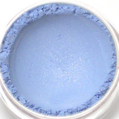 Close-up of fingertips applying light blue shimmer eyeshadow with soft mineral powder texture to eyelid
