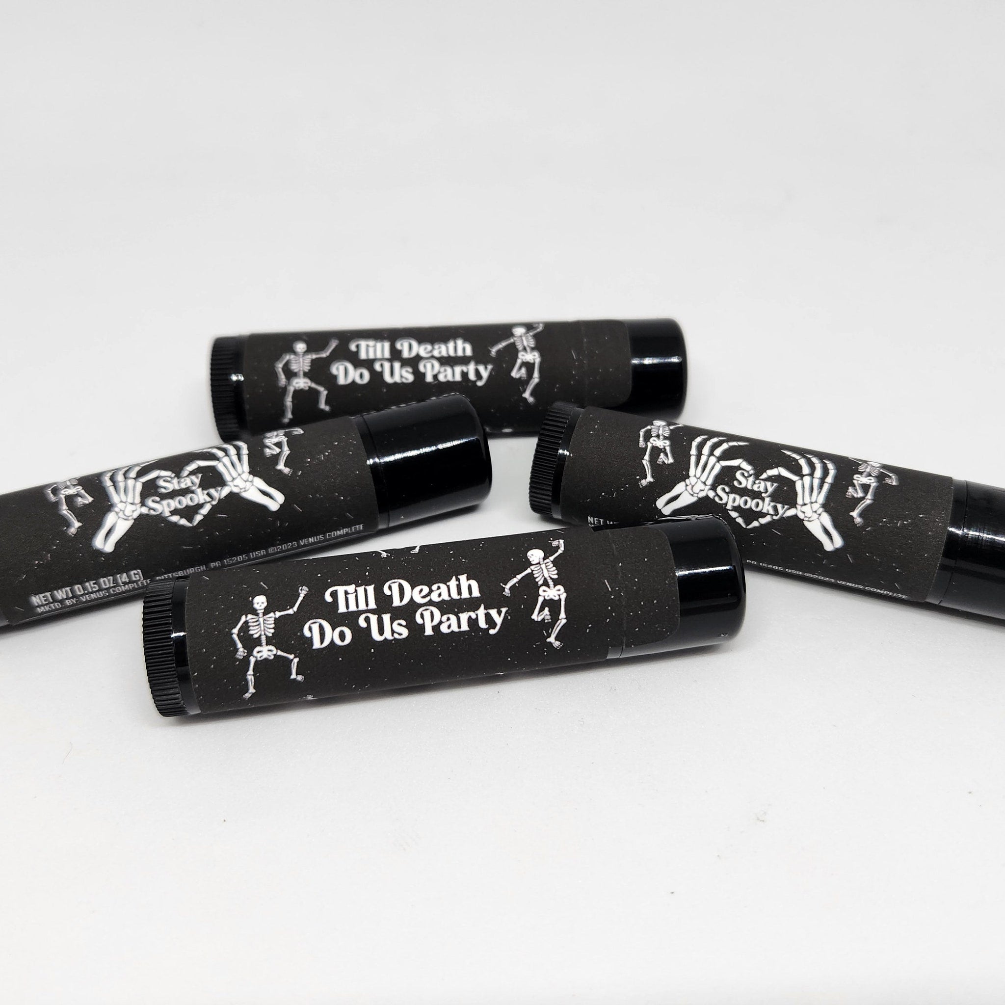 Lip balm tubes with black and white skeleton design, "Stay Spooky" and "Till Death Do Us Party" text
