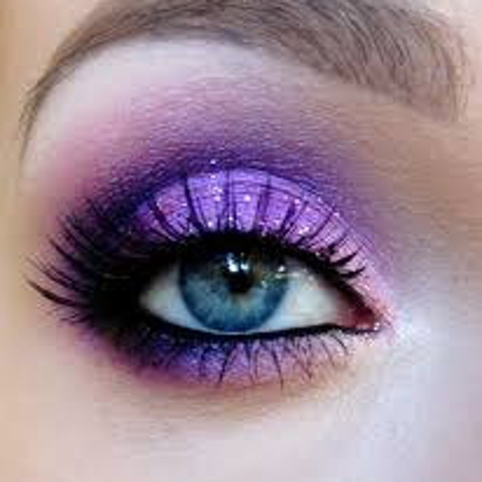 Close-up of pressed mineral purple eyeshadow cake with shimmering flecks in compact case