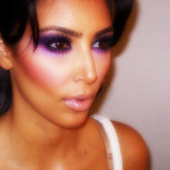 Woman applying shimmering purple mineral eye shadow with a fluffy brush for a soft blended look