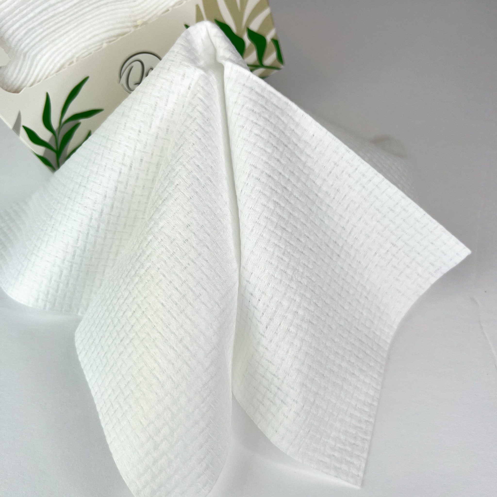 White tissue with woven texture, pulled from a box with leaf design