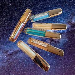 Lip gloss tubes with gold caps and LUMICHROME text, various colors visible