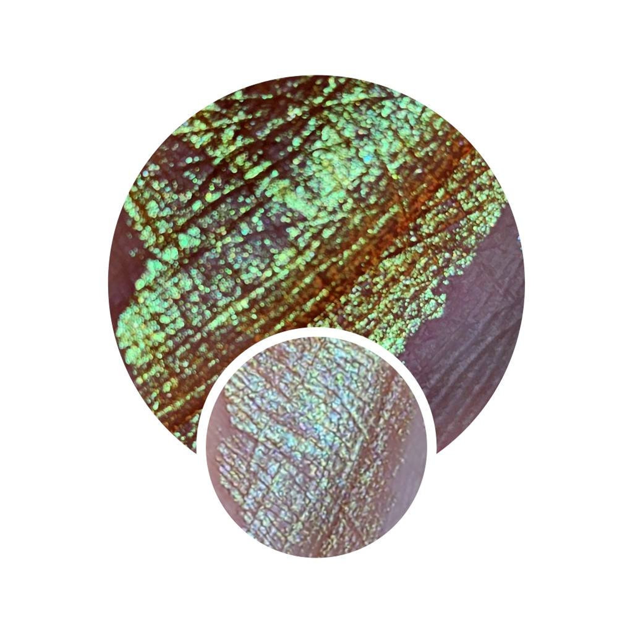 Liquid eyeshadow swatch with green and orange shimmer on skin, Lumichrome product detail
